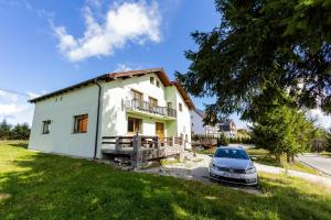 una casa con un coche aparcado delante en Vila Verde Păltiniș, en Poplaca