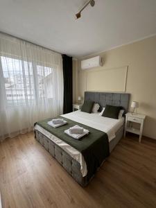 Un dormitorio con una cama grande y una ventana grande. en Bliss Studio, en Slatina