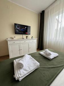 1 dormitorio con 2 toallas en una cama y TV en Bliss Studio, en Slatina