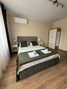 ein Schlafzimmer mit einem großen Bett, auf dem zwei Handtücher liegen in der Unterkunft Bliss Studio in Slatina