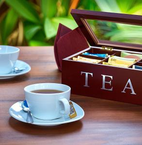 a cup of coffee and a box of tea on a table at Waterland in Negombo