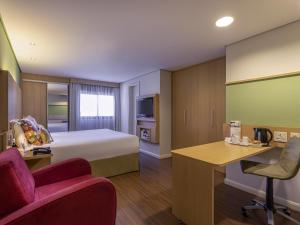 a hotel room with a bed and a desk and chairs at Mercure São Paulo Nações Unidas in Sao Paulo