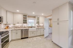 a kitchen with white cabinets and stainless steel appliances at Walk to Frog Level Historic District! Home with Deck in Waynesville
