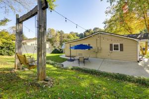 a patio with a table and a blue umbrella at Walk to Frog Level Historic District! Home with Deck in Waynesville