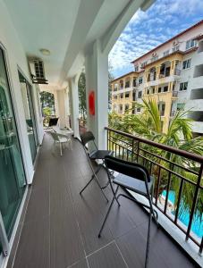 a balcony with chairs and a view of a building at Tiara Desaru seaview homestay-poolbeachview in Bandar Penawar
