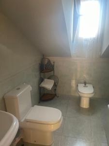 a bathroom with a toilet and a sink and a window at Asturica in Astorga