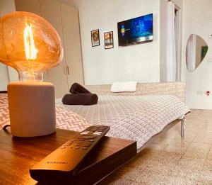 a bedroom with a bed with a remote control on a table at Echoes room 20 minuti dal centro di Firenze in Prato