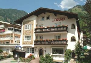 ein großes weißes Gebäude mit Blumen auf dem Balkon in der Unterkunft Hotel zum Toni in Bad Hofgastein