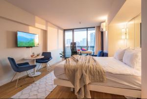 a bedroom with a large bed with a tv on the wall at PANORAMA Resort - Center Suite & Sea View in Batumi