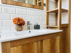 a bathroom sink with a vase of flowers on it at Dom nad jeziorem Miedwie, Zieleniewo in Zieleniewo +43 photos