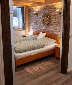 een slaapkamer met een bed in een bakstenen muur bij Gemütlichkeit in Heltersberg