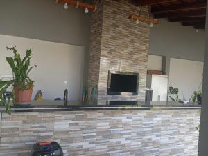 a living room with a fireplace and a tv at Quarto casal in Itaqui