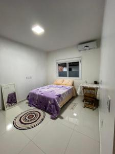 une chambre avec un lit et une table dedans dans l'établissement Quarto casal, à Itaqui