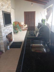 une cuisine avec un évier et une cheminée dans l'établissement Quarto casal, à Itaqui 4 autres photos