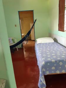 Habitación con cama y hamaca. en Chalé Rústico Cumuruxatiba, en Cumuruxatiba