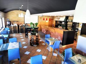 a restaurant with blue chairs and a bar at Hotel ibis Leiria Fatima in Leiria