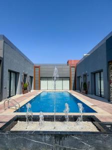 a swimming pool with a fountain in front of a building at Villa Ramona in Marrakech