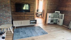 a living room with a flat screen tv and a kitchen at Jaani Mardi Puhkemaja in Sooaluse