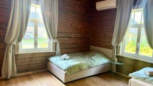 a small bedroom with a bed and two windows at Jaani Mardi Puhkemaja in Sooaluse