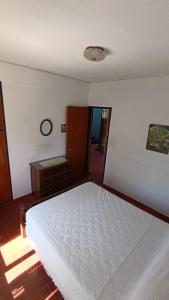 a bedroom with a white bed and a dresser at Apartamento Gesell in Villa Gesell