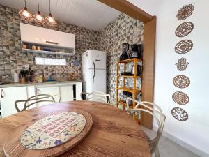 Una cocina y un comedor con mesa y sillas de madera. en Casa Silandia Búzios, en Búzios 15 fotos más