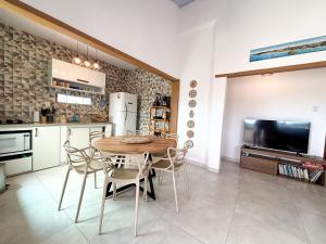 Una cocina y un comedor con mesa y sillas. en Casa Silandia Búzios, en Búzios