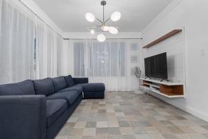 a living room with a blue couch and a television at Pr Rentals Expectacular Location in San Juan
