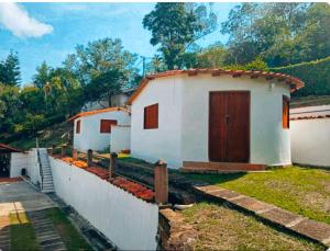 a small white house with a fence and a yard at Aires de Encanto in Curití +18 photos