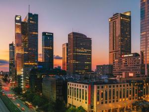 a city skyline with tall skyscrapers at night at Mercure Warszawa Centrum in Warsaw