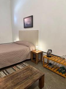 MiramarHabitaciones Casona Las Toscas的一间卧室配有一张床、一张桌子和一张桌子