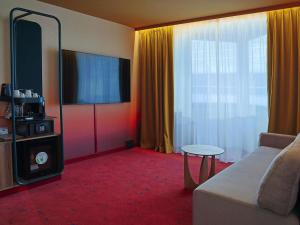 a living room with a couch and a large window at Mercure Warszawa Centrum in Warsaw