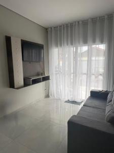 a living room with a couch and a large window at Estadia Incrível Aconchego e Praticidade Juntas in Lucas do Rio Verde