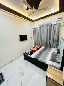 a bedroom with a bed and a ceiling fan at Ram Bhawan HomeStay in Vrindāvan