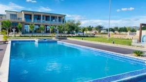 a large blue swimming pool in front of a building at Quiet Waters Resort in Kafue