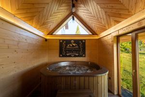 a large wooden tub in a room with a window at Willa Paula - Jacuzzi, Sauna & Grill in Ząb