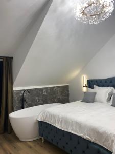 1 dormitorio con bañera junto a la cama en EleS Chalet, en Brebu 9 fotos más
