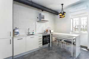 a kitchen with white cabinets and a counter top at Casa Malpique in Albufeira
