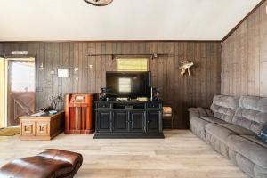un soggiorno con divano e TV a schermo piatto di LaRue's Private Lakeside Cottage ad Abbeville