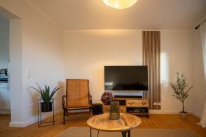 a living room with a tv and a table at Ferienwohnung - Ewigkeit in Minden