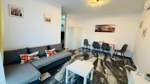 a living room with a couch and a table at Felicia Apartments in Arad