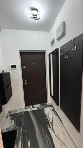 a bathroom with two black doors and a marble floor at Felicia Apartments in Arad +20 photos