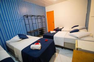 two beds in a room with blue and white at Pousada Dois Irmãos in Fernando de Noronha