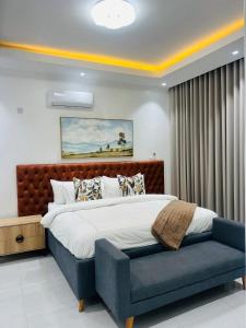 1 dormitorio con 1 cama grande y un banco azul en Tranquil Ridge BnB, en Blantyre