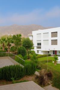 a white building in the middle of a yard at Résidence Tafoult Imiouadar près de Taghazout Agadir in Imi Ouaddar