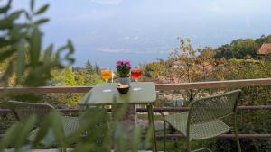 - une table avec deux verres à vin et un vase de fleurs dans l'établissement Viator Vale, à Tremosine