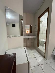 ein Badezimmer mit Badewanne, Waschbecken und Spiegel in der Unterkunft Pousada Flor de Ipê - Arraial d'Ajuda - a 100m da Rua do Mucugê - principal Rua da cidade in Arraial d'Ajuda