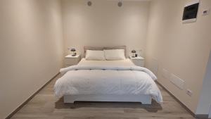 une chambre blanche avec un lit et deux tables de nuit dans l'établissement Viator Vale, à Tremosine