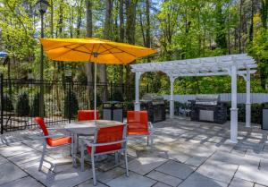mesa y sillas con sombrilla y parrilla en Crest At East Cobb 1828d Serene 2bd 15bt, en Marietta