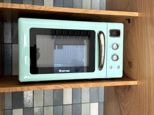 a blue microwave sitting on a wooden shelf at Simple La Jolla Epic bungalow # 3 in San Diego