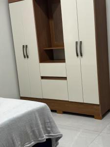 a bedroom with white cupboards and a bed with at Estadia Incrível Aconchego e Praticidade Juntas in Lucas do Rio Verde